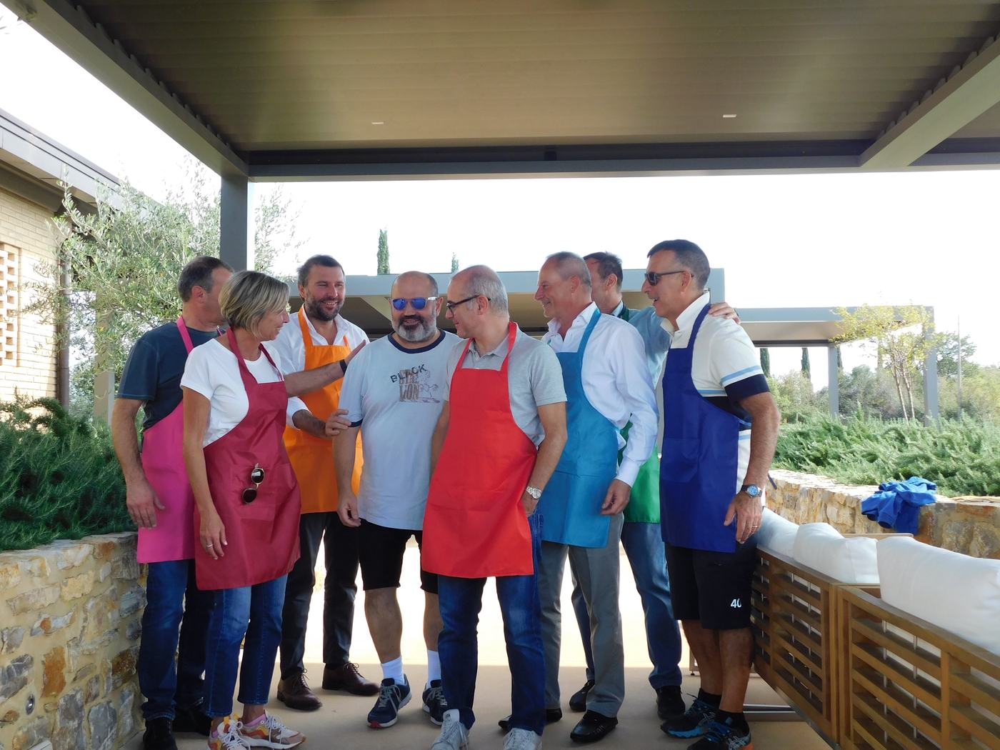 Un gruppo di colleghi con grembiuli colorati prima di una sessione
